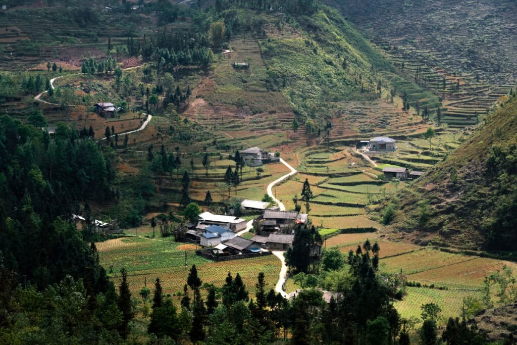 Captivating aerial view of terraced fields and houses in Hà Giang, Vietnam, showcasing rural beauty.