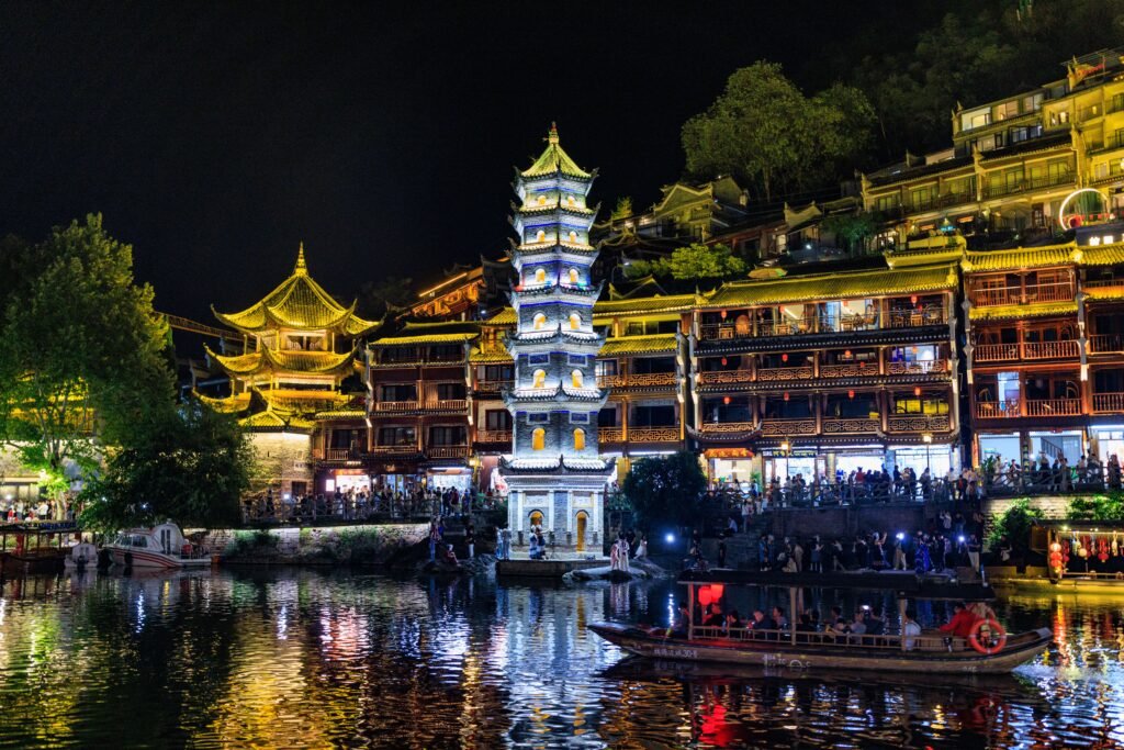 Stunning view of a pagoda and traditional buildings reflecting in water at night.