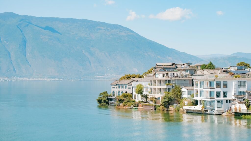 Charming waterfront homes by Erhai Lake in Dali, China, with mountain backdrop.