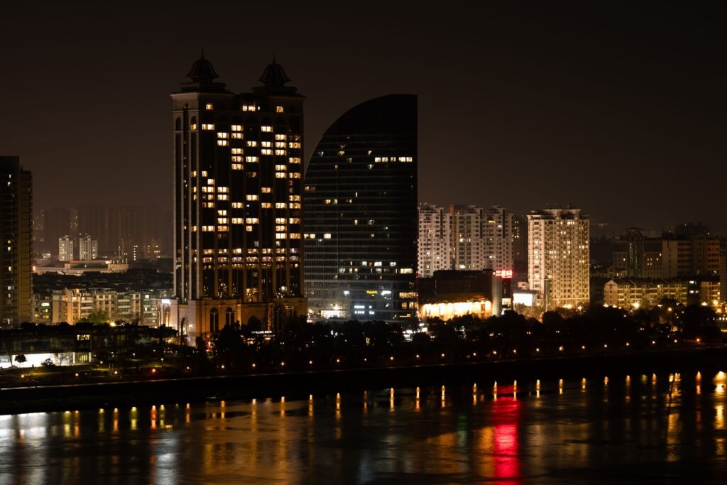 Stunning nighttime view of Hangzhou's illuminated skyline reflecting on the river.